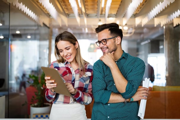 two coworkers reviewing details on a tablet