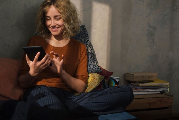 Smiling Woman Relaxing at Home with Tablet