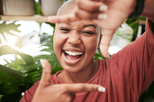 woman smiling framing her face with her hands