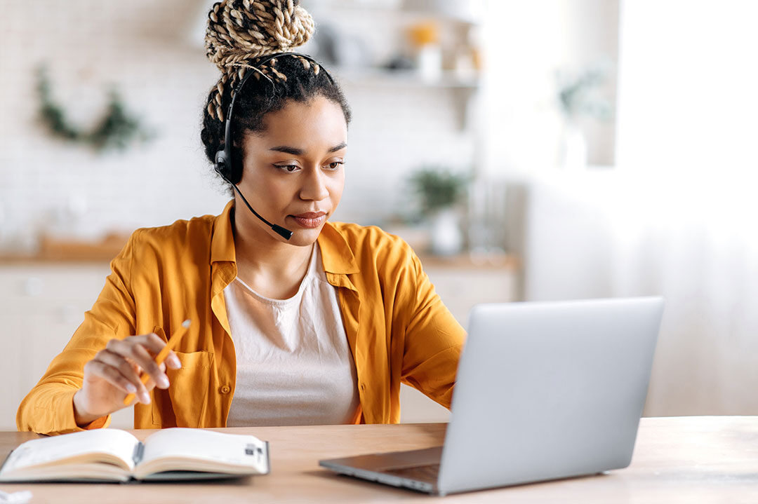 employee with headset in front of laptop