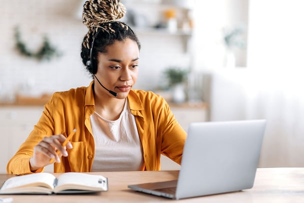 employee with headset in front of laptop