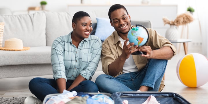 Couple planning their trip while packing.