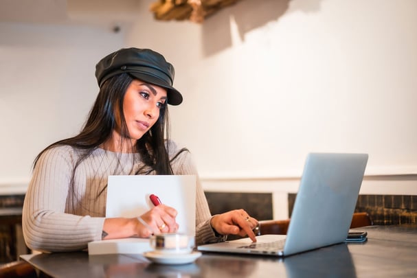 Brunette girl teleworking in a cafe with her laptop