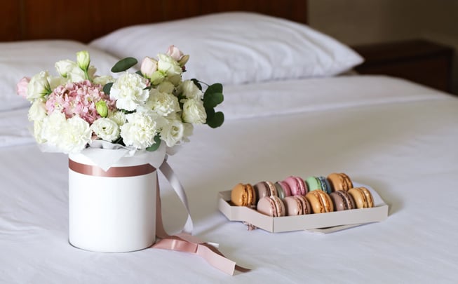 Elegant Flowers and Macarons on White Bed Linens