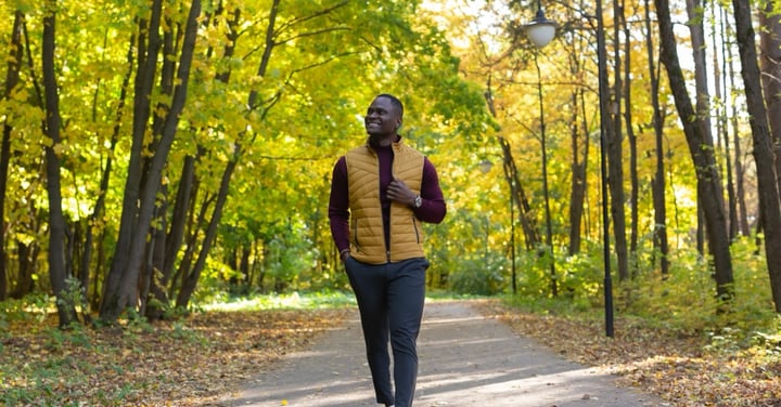 Man enjoys leisure walk in sunny autumn park