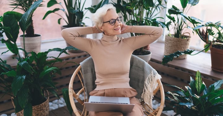 Senior woman relaxing at home surrounded by plants