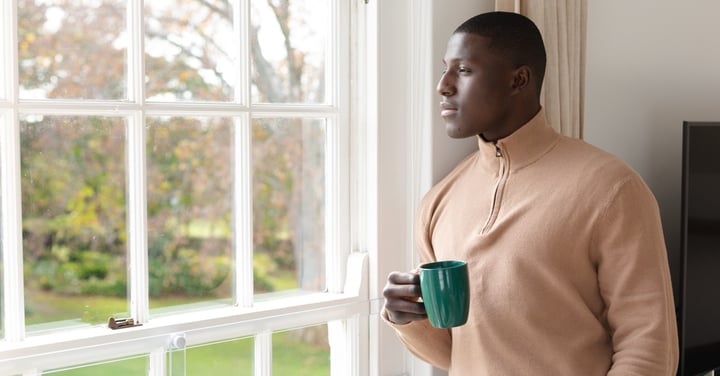 Man relaxing and looking out of window