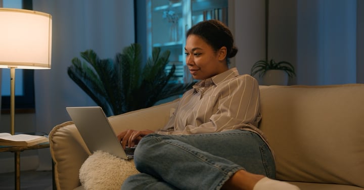 Woman relaxing on sofa while using laptop