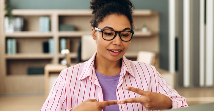Smiling woman using sign language online meeting