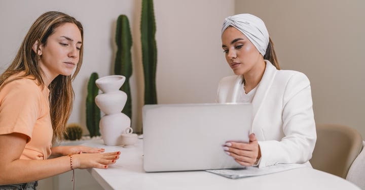 Women working together at desk with laptop