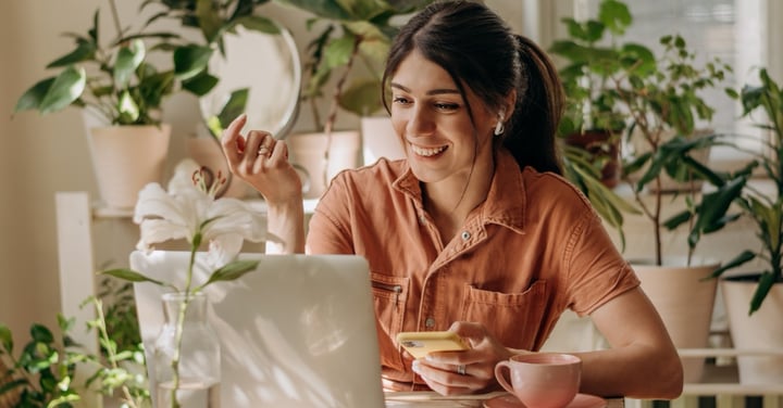 Smiling woman working at home surrounded by plants