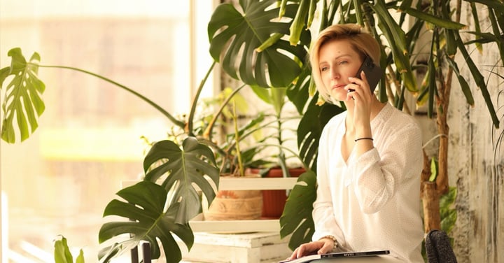 Woman talking on the phone surrounded by plants