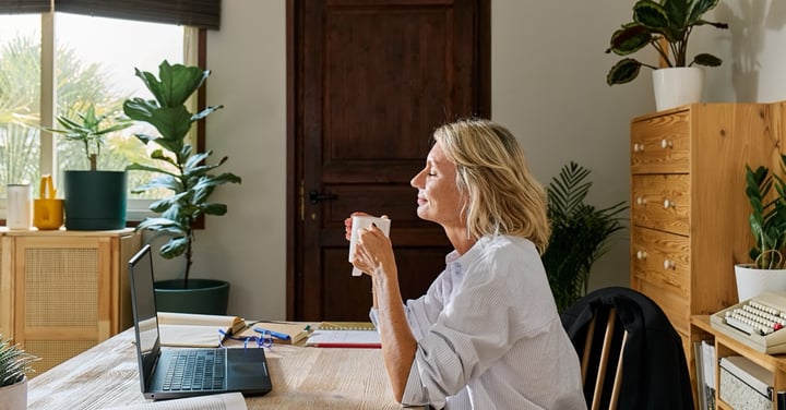 Relaxed woman enjoying coffee at her home workspace
