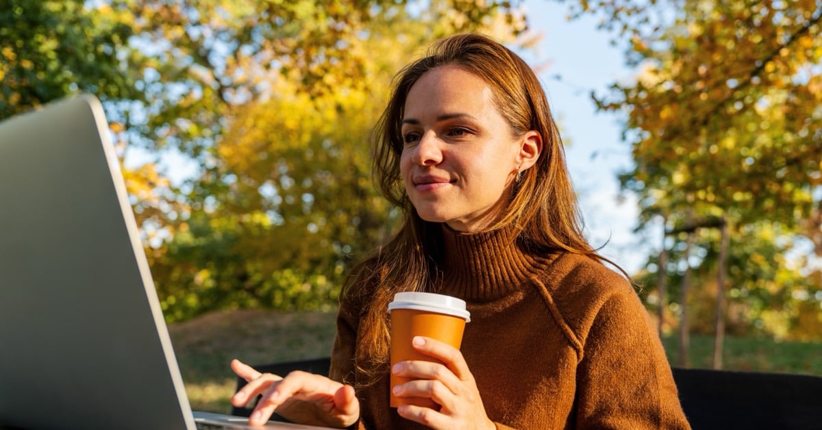 Woman works on laptop while outdoors