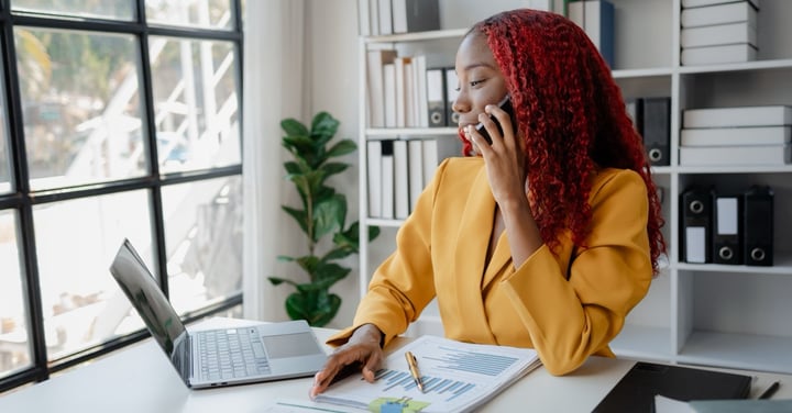 Businesswoman working at desk talking on phone