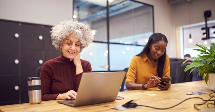 Smiling women working on computers in office