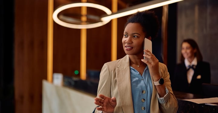 Hotel guest on mobile phone at front desk