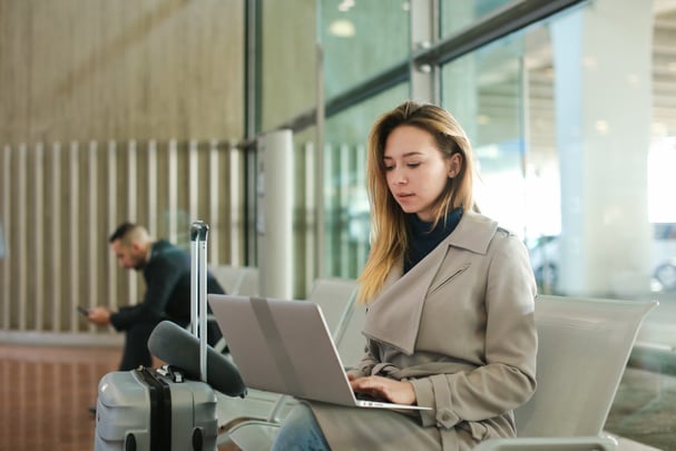 Woman sitting at airport on laptop.