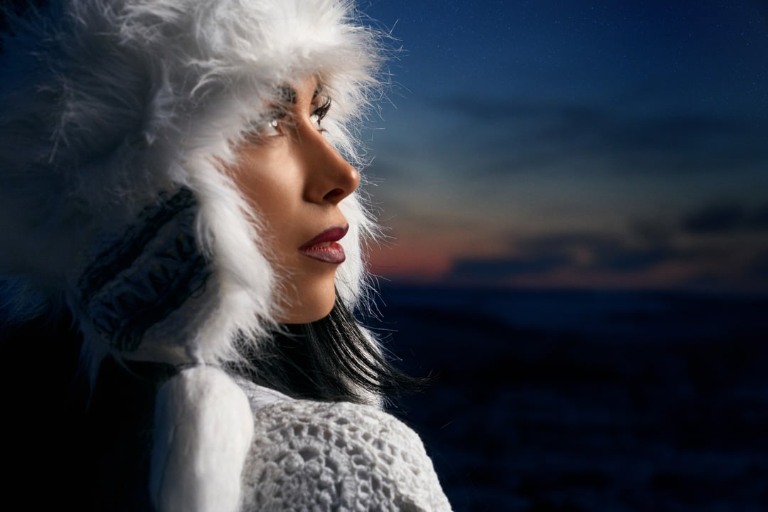 Model in winter white hat on background of night sky