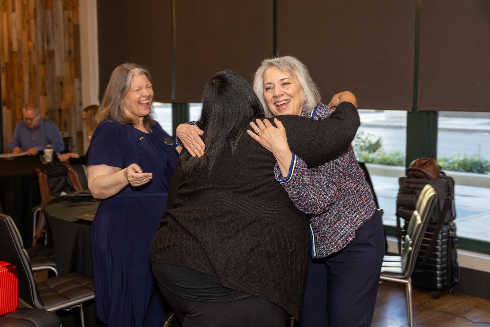 WorldVia Travel Network members hugging hello at a Roadshow
