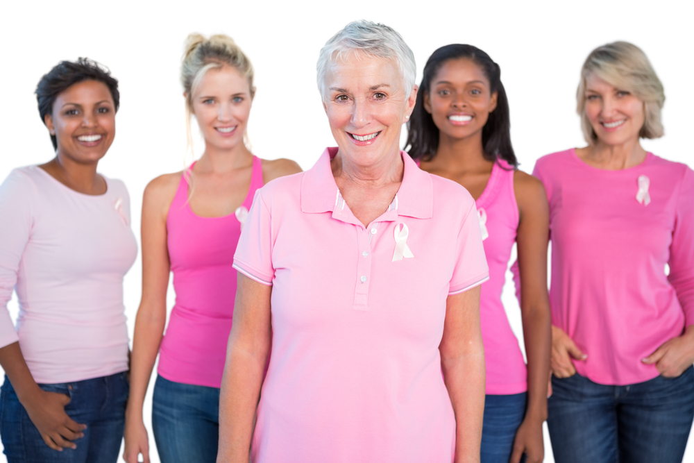 Diverse group of women wearing pink tops and breast cancer ribbons on white background Diverse group of women wearing pink tops and breast cancer ribbons on white background
