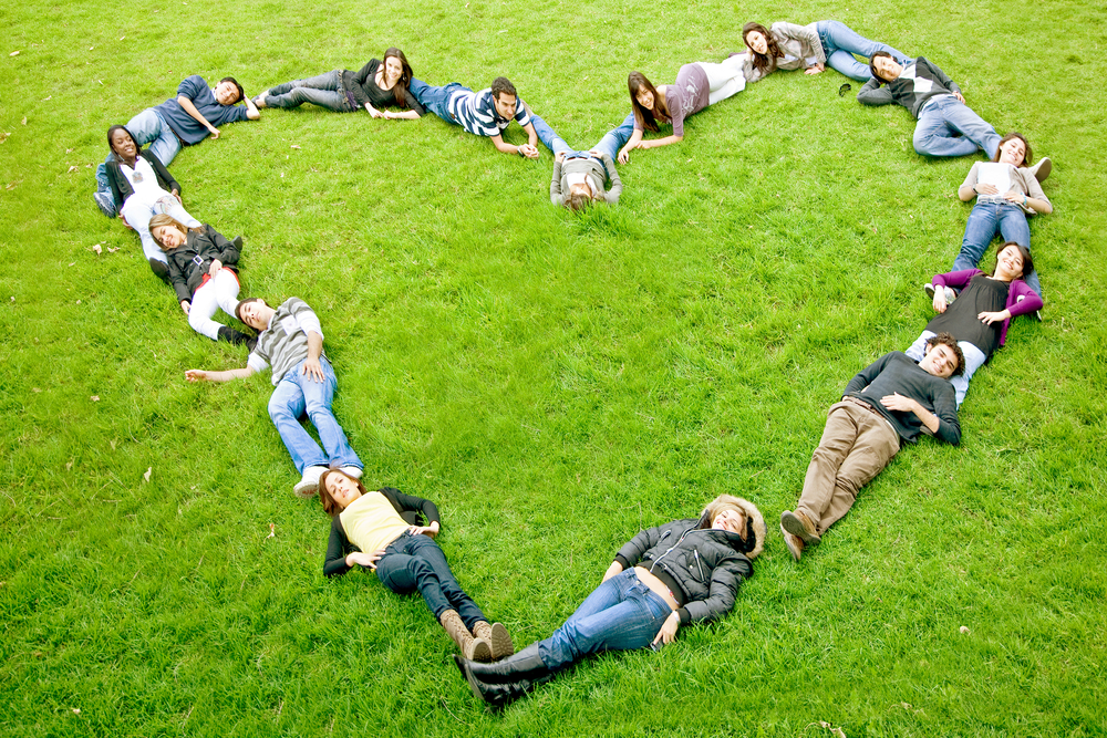 happy group of friends making a heart shape - smiling outdoors in a park-1