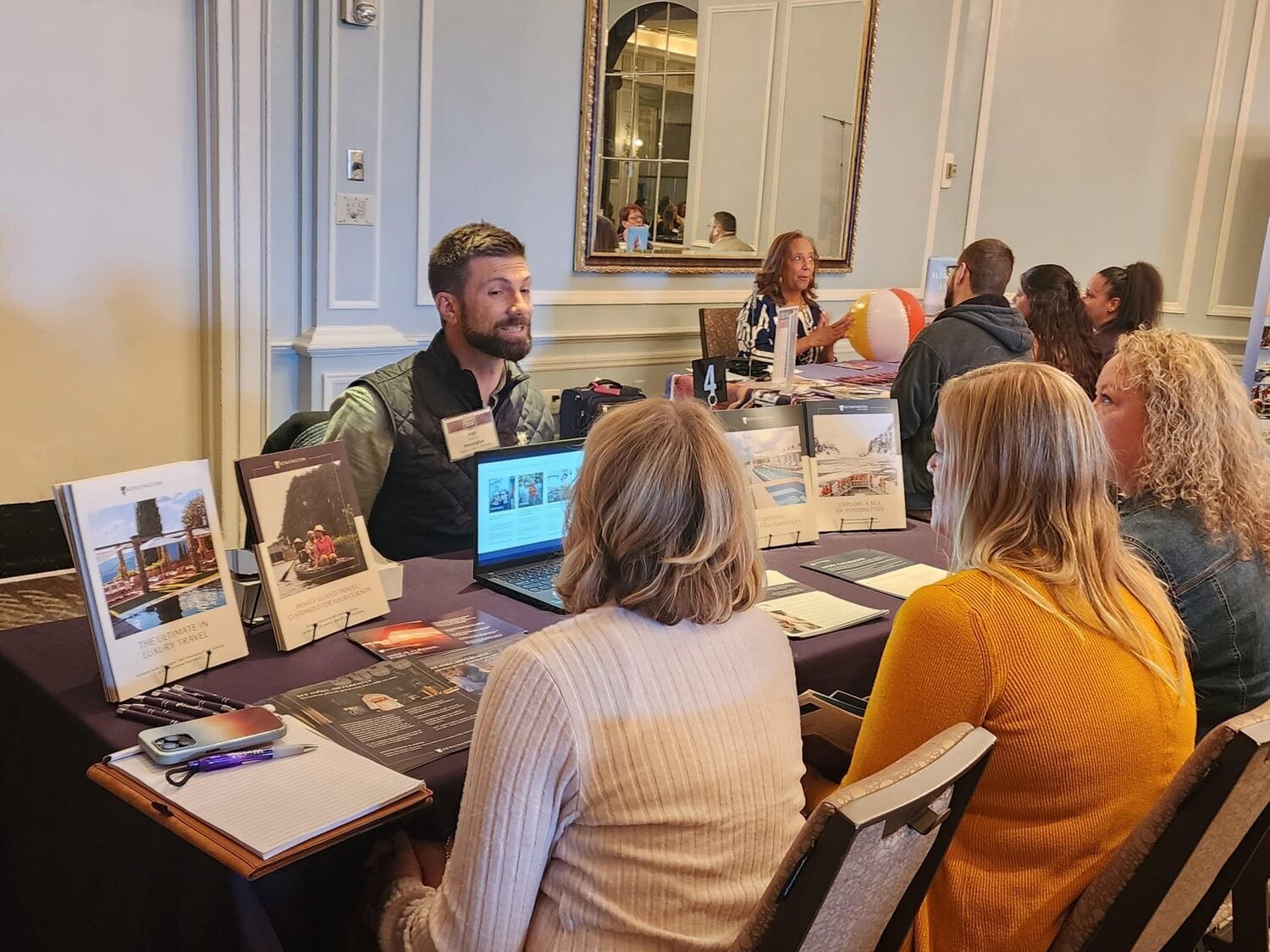 A travel advisor and a supplier partner deep in conversation across a partner table at the Roadshow