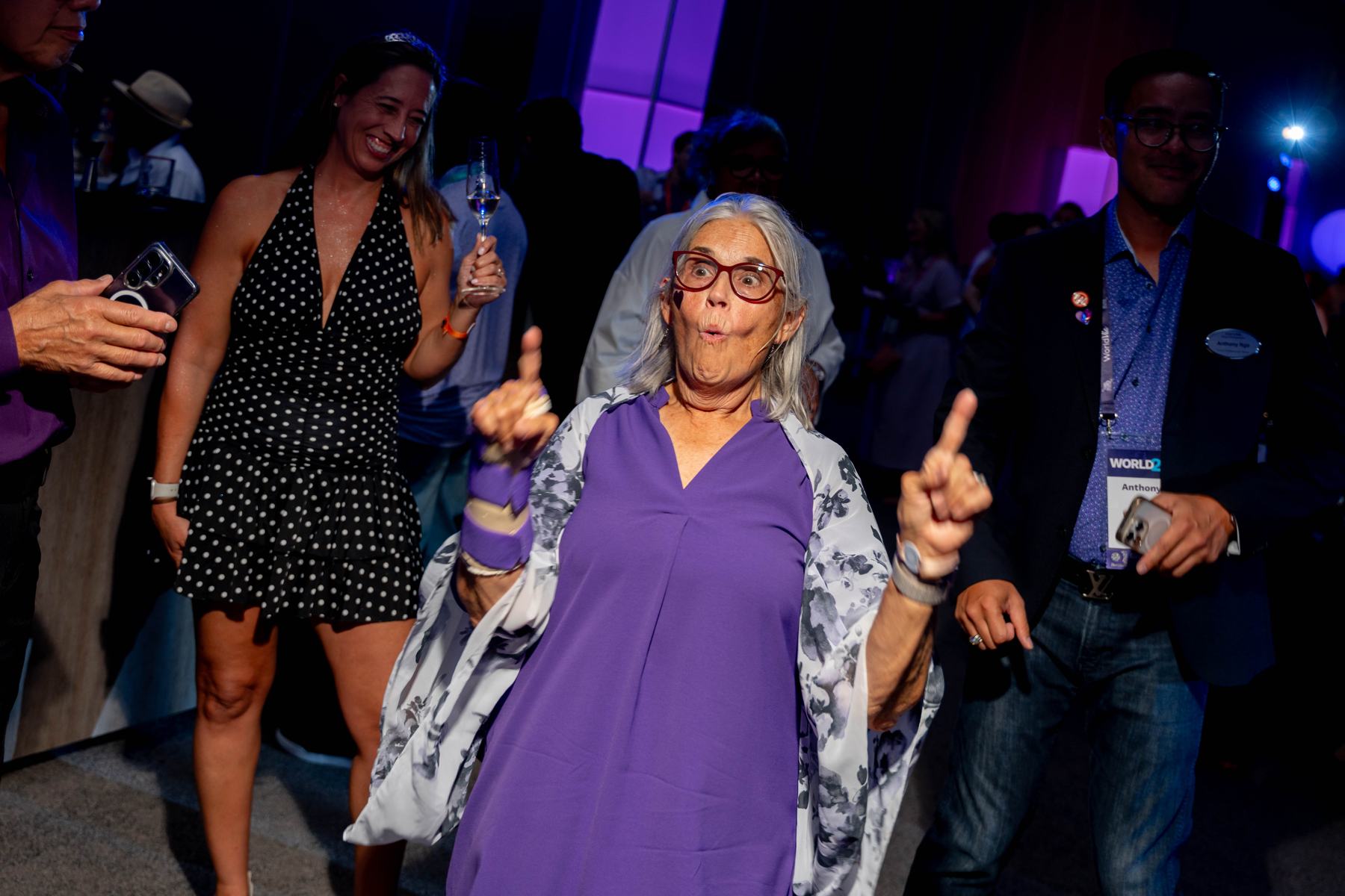 A member celebrating on the dance floor at the Purple Party