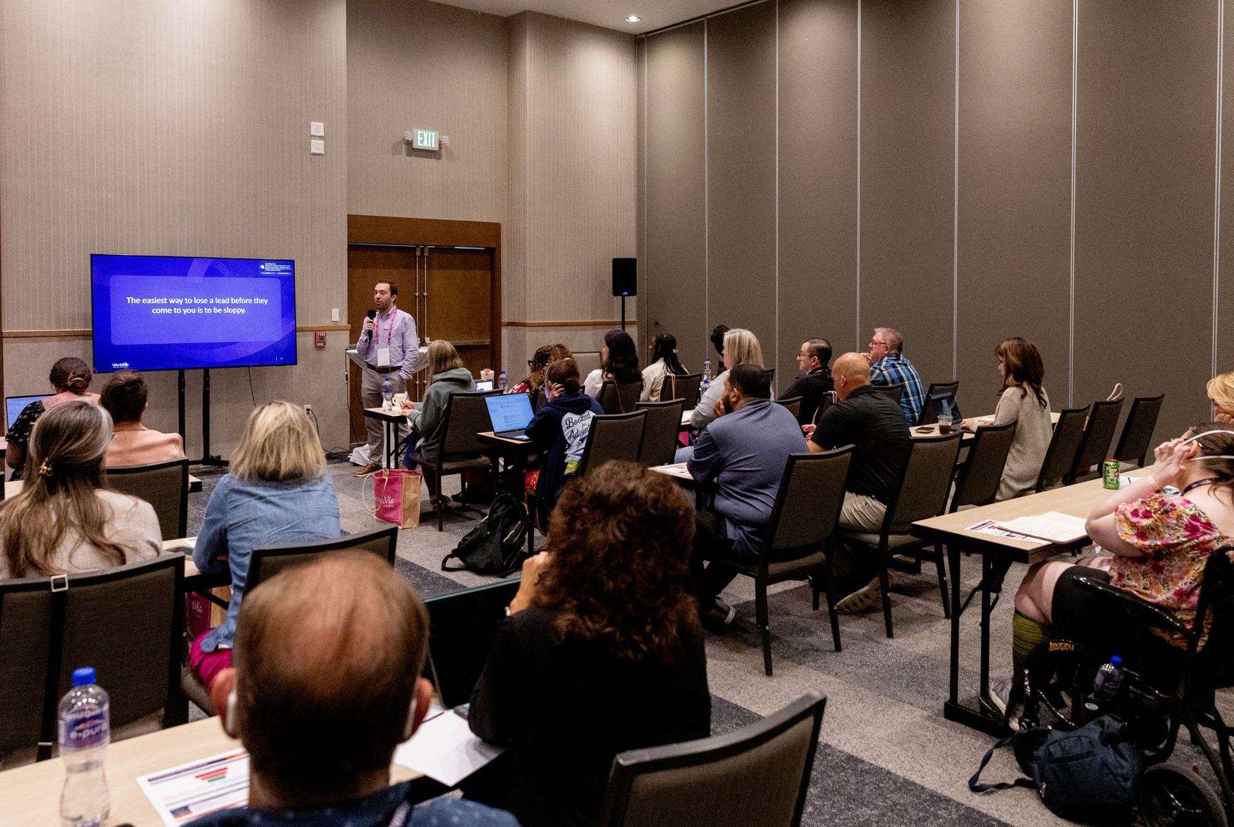 Advisors taking notes in a packed WorldVia Academy breakout session at WORLD26