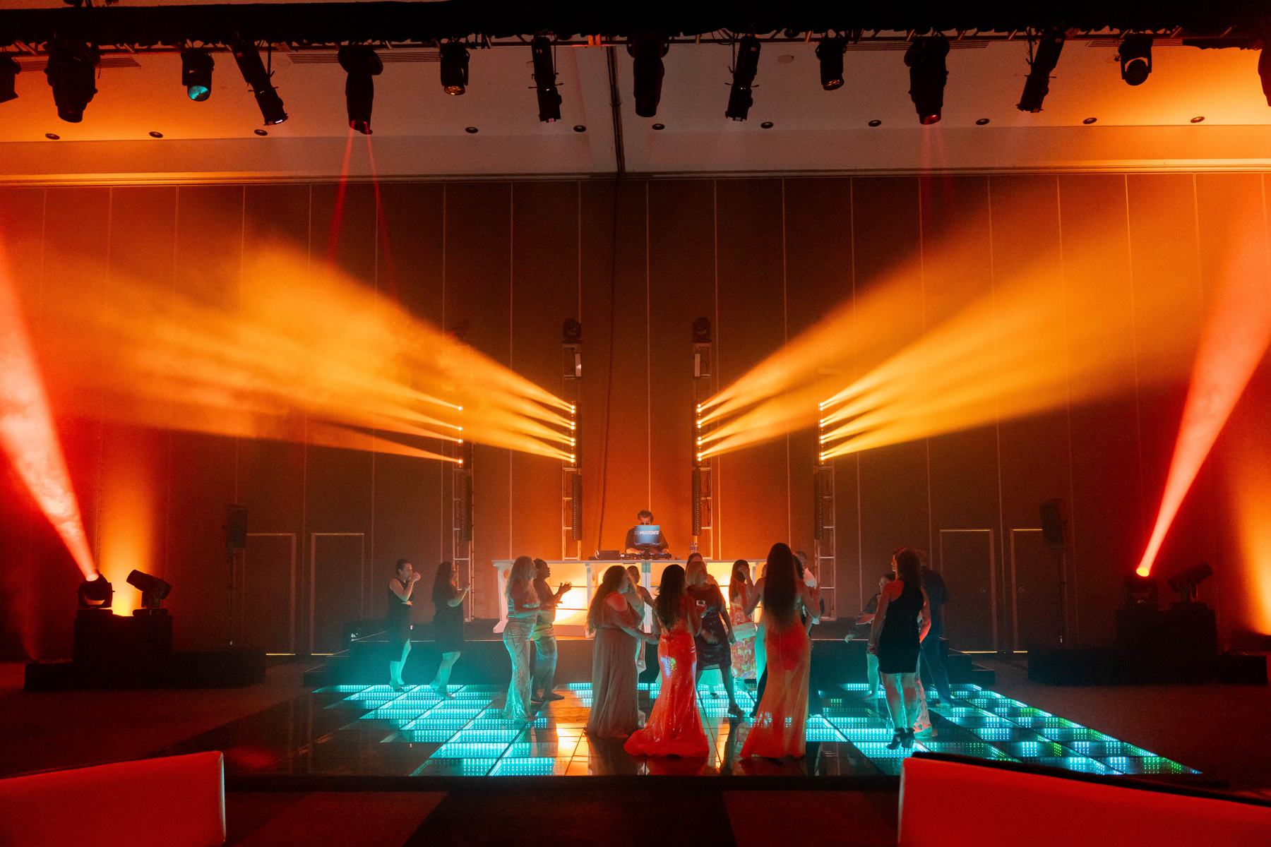 The WORLD26 dance floor under orange stage lights