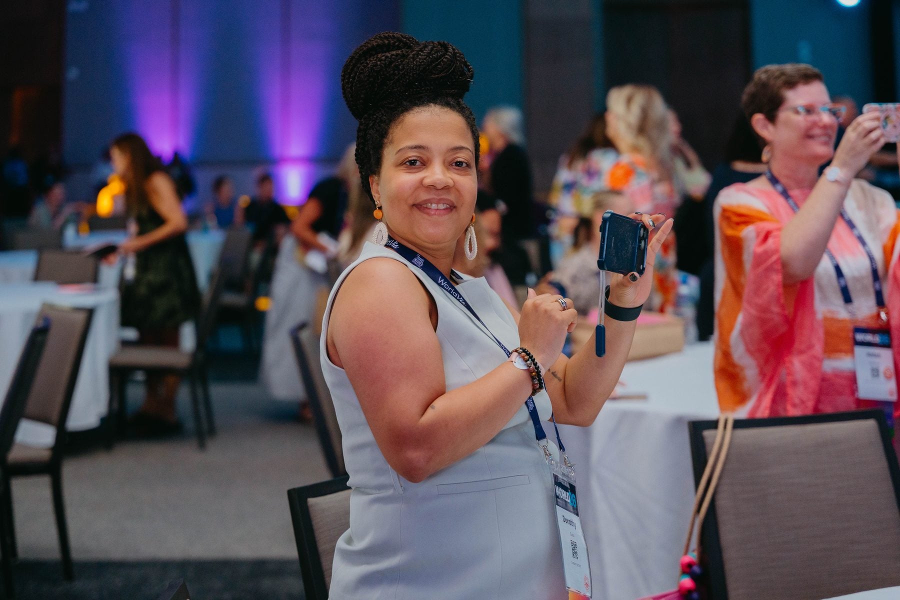 Members smiling and taking photos during a WORLD26 general session
